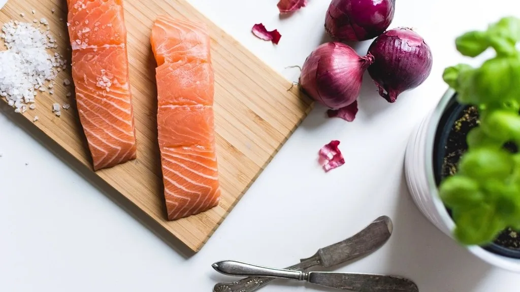 Lomos de salmón crudo con sal gruesa sobre una tabla