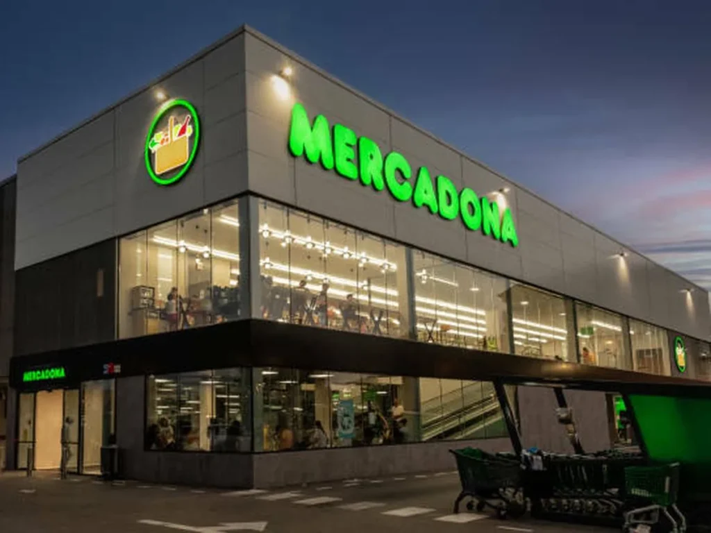 Fachada de un supermercado Mercadona iluminado al anochecer