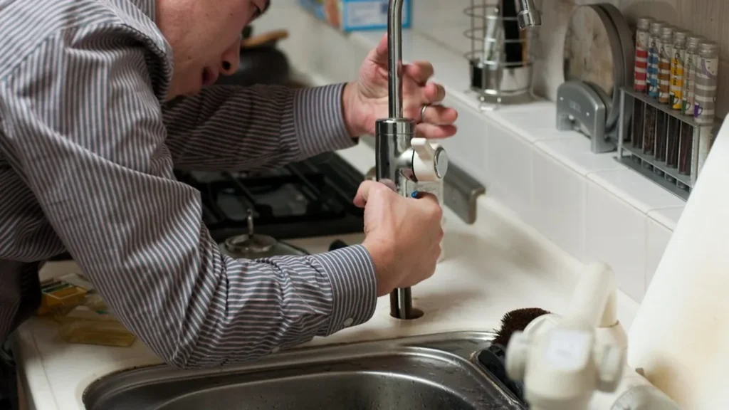 Fontanero arreglando un grifo de cocina
