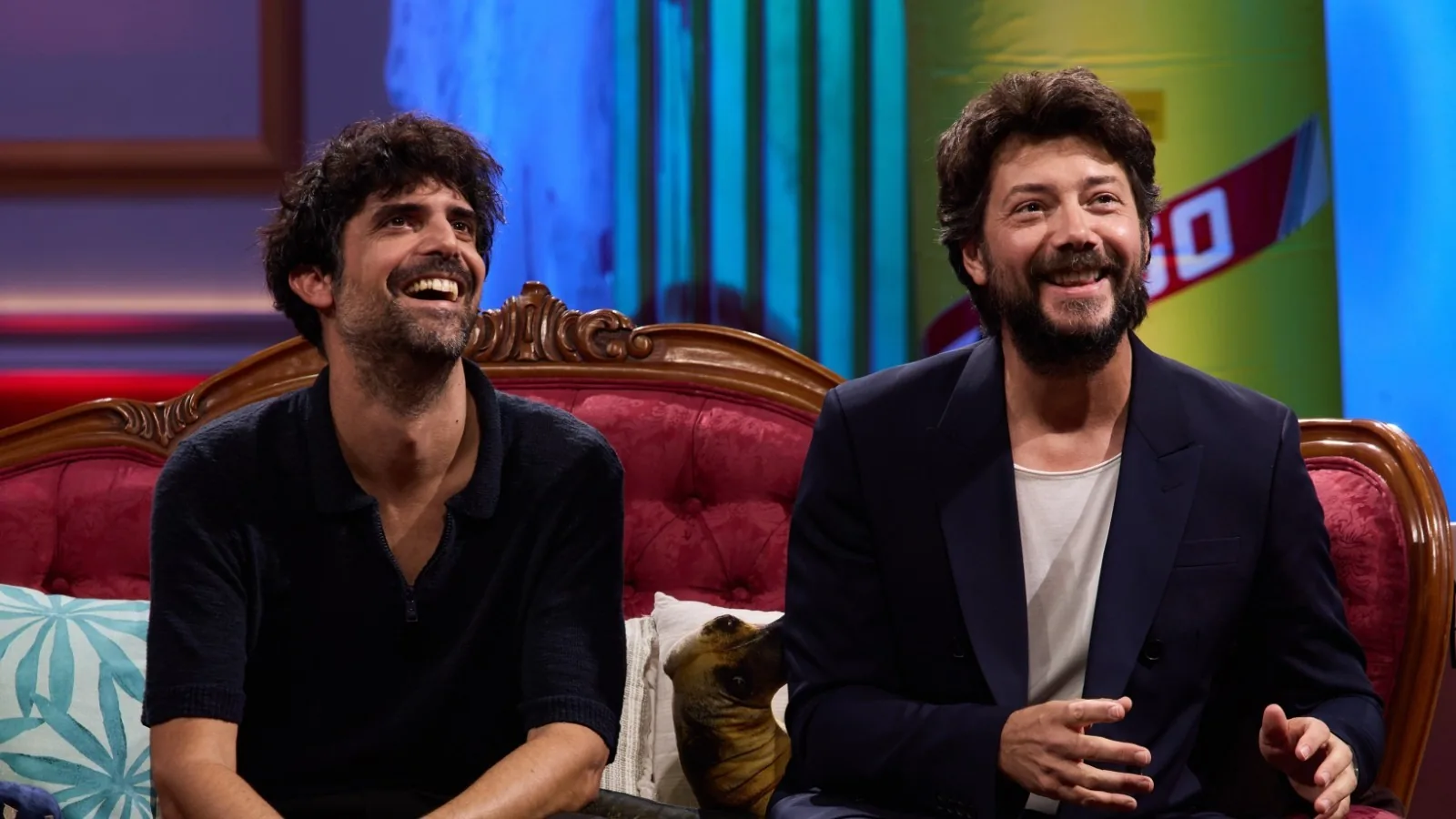 Francesco Carril y Álvaro Morte riendo en el sofá de La Revuelta