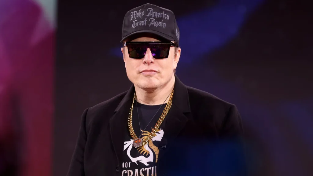 Elon Musk, con gorra negra y gafas de sol, en un acto en 2025
