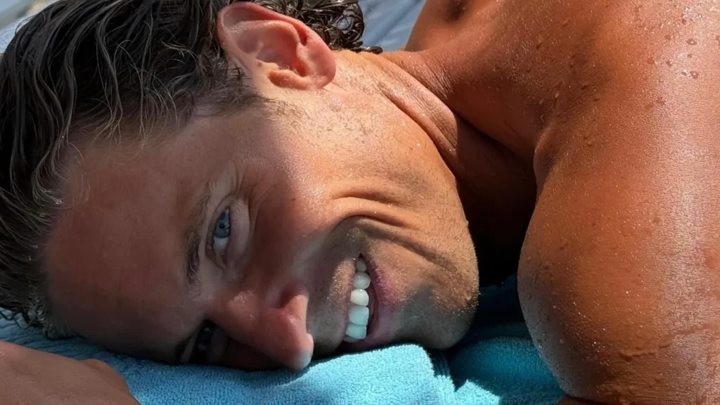 Marcos Llorente sonriendo, tumbado sobre una toalla al sol