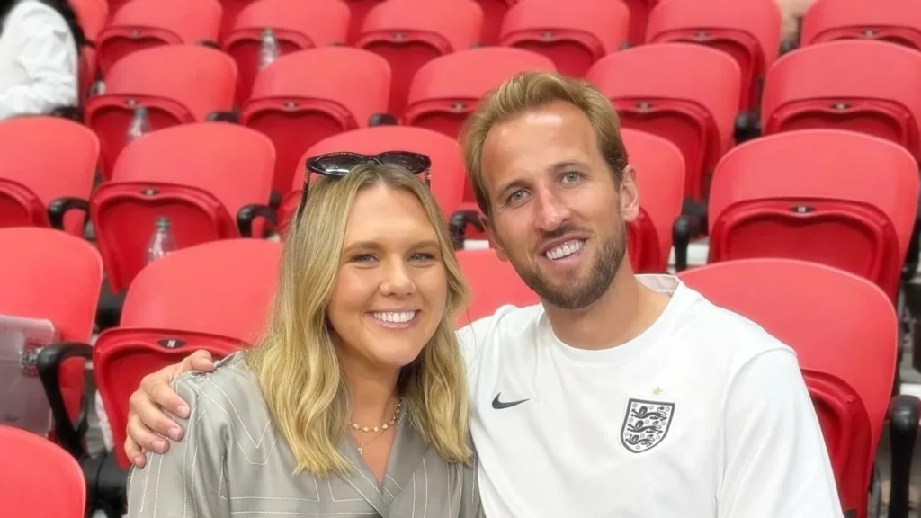 Katie Goodland y Harry Kane sonriendo en la grada de un estadio